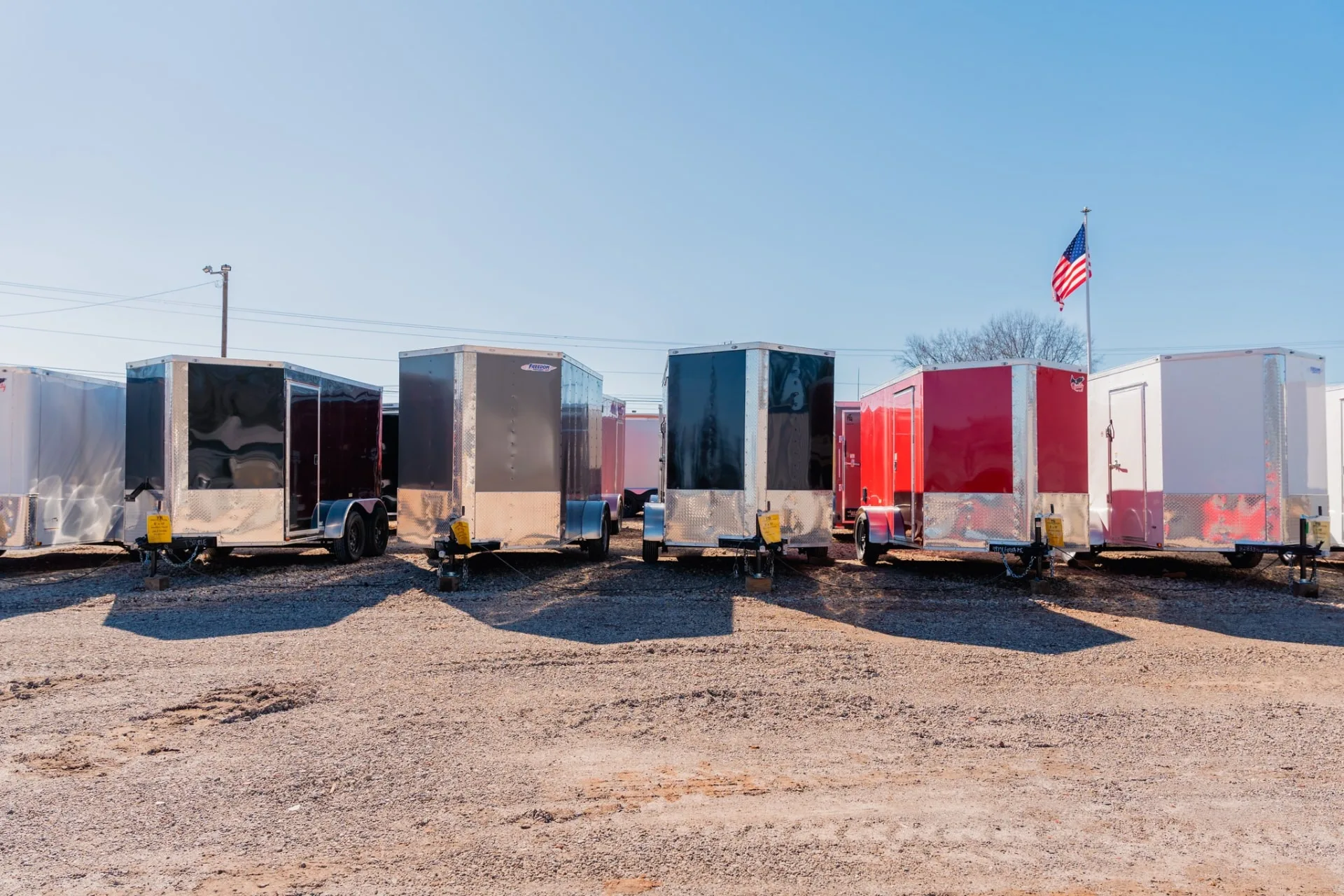 Enclosed and utility trailers lined up for sale at Trailer Source in Greenville